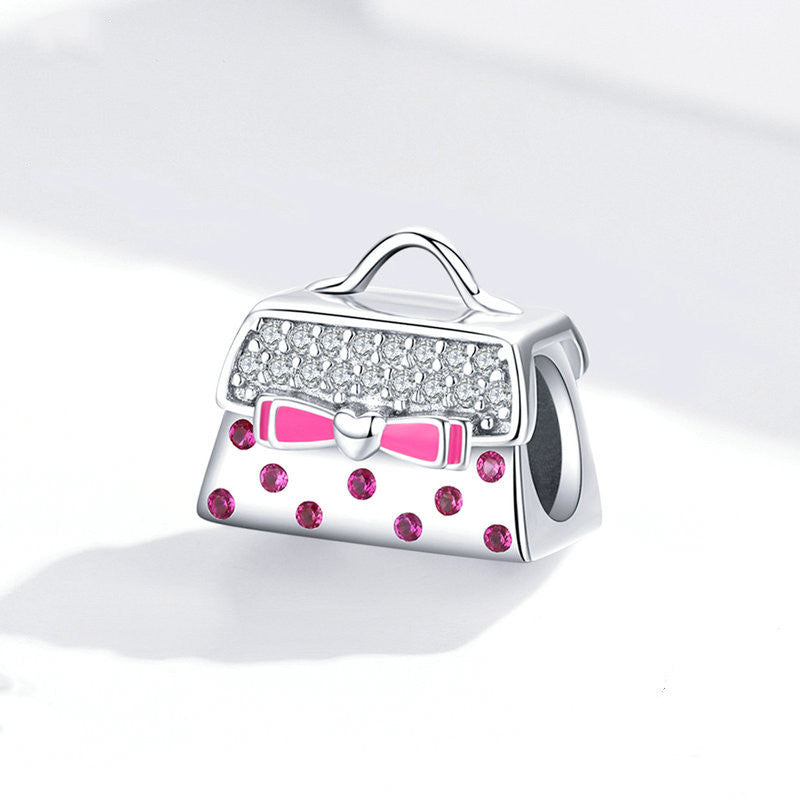 A Maramalive™ silver bracelet with a pink polka dot charm.