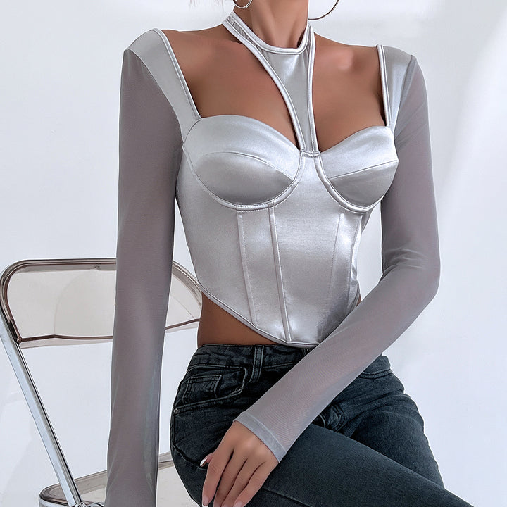 A person wearing a stylish silver Hot Girl Low-cut Sexy See-through Mesh Patchwork Halter Top Female by Maramalive™, paired with dark jeans, and exuding street fashion vibes is seated on a foldable chair against a plain background.