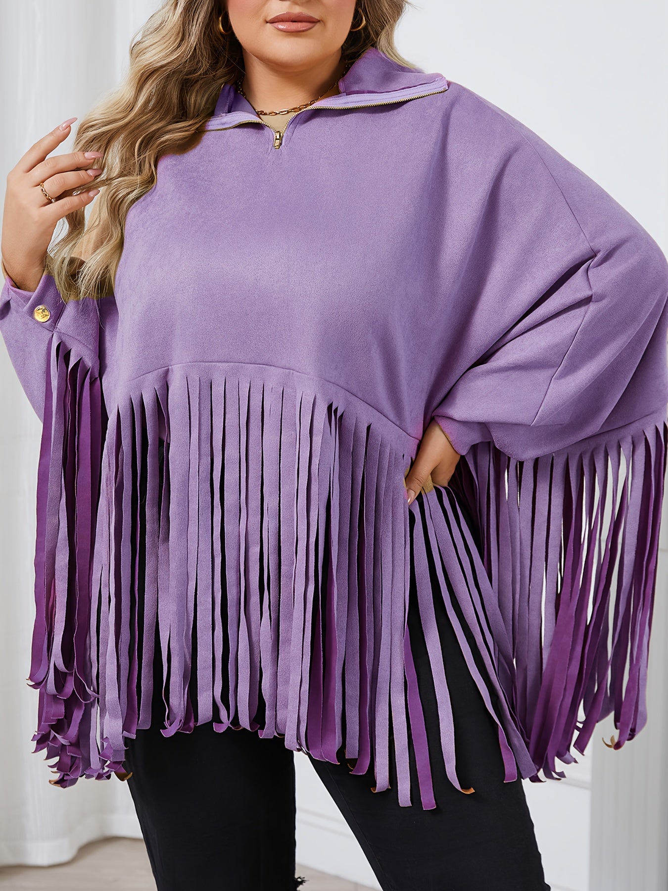 Person wearing a Maramalive™ Plus Size Trendy Top, Women's Plus Solid Batwing Sleeve Mock Neck Fringe Trim Cloak Top in light purple, standing indoors.