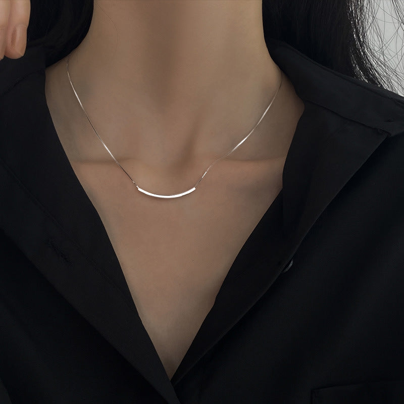 A woman wearing a black shirt with a Women's Smiley Curved Clavicle Chain by Maramalive™.
