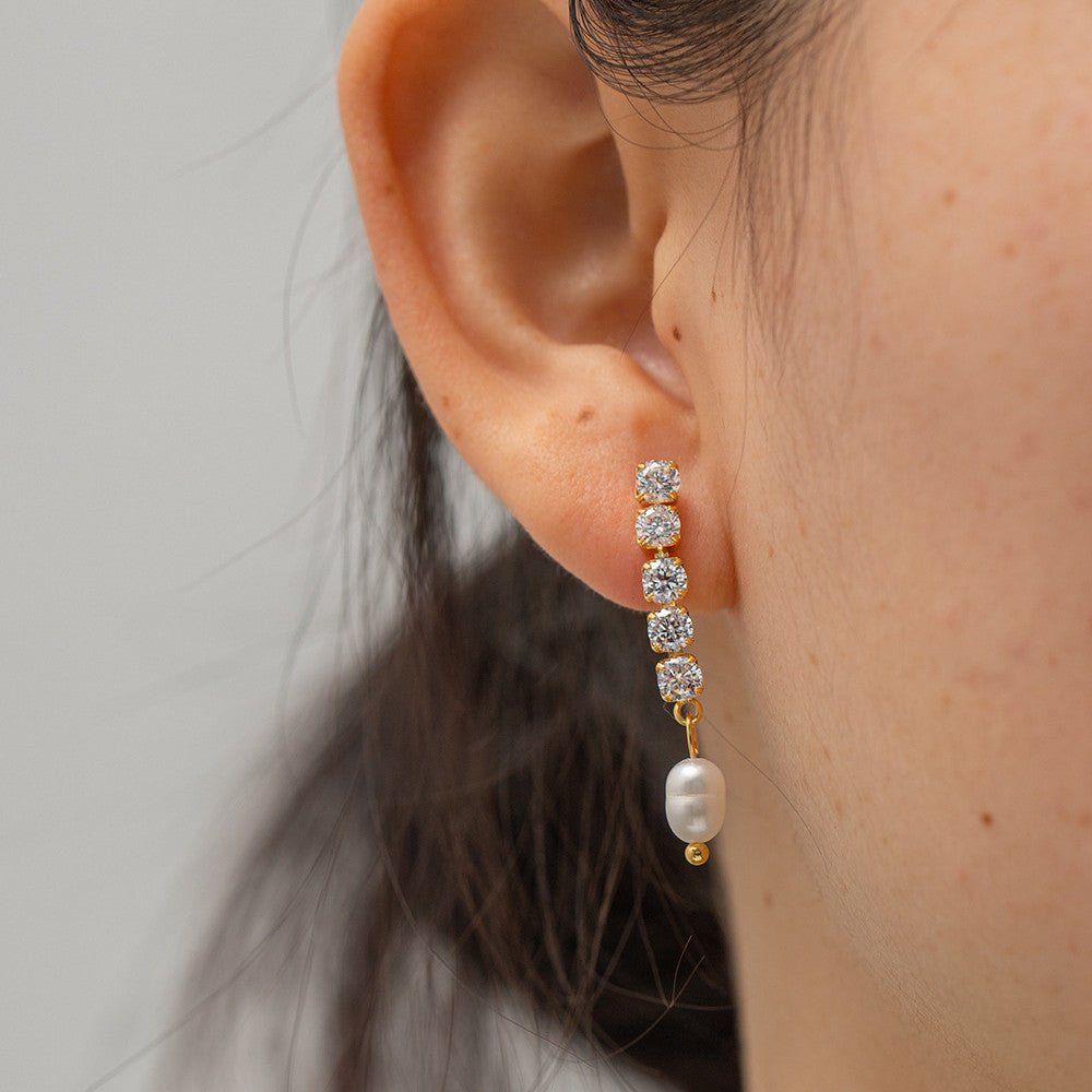 A woman wearing a pair of Graceful And Fashionable Exquisite Micro Inlaid Zircon Freshwater Pearl Ear Studs by Maramalive™ with pearls and diamonds.