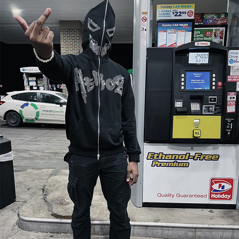 A man with a super attitude in a unisex gothic dark Diamante-Studded Hoodie Sweatshirt for Edgy Style by Maramalive™ standing next to a gas pump.