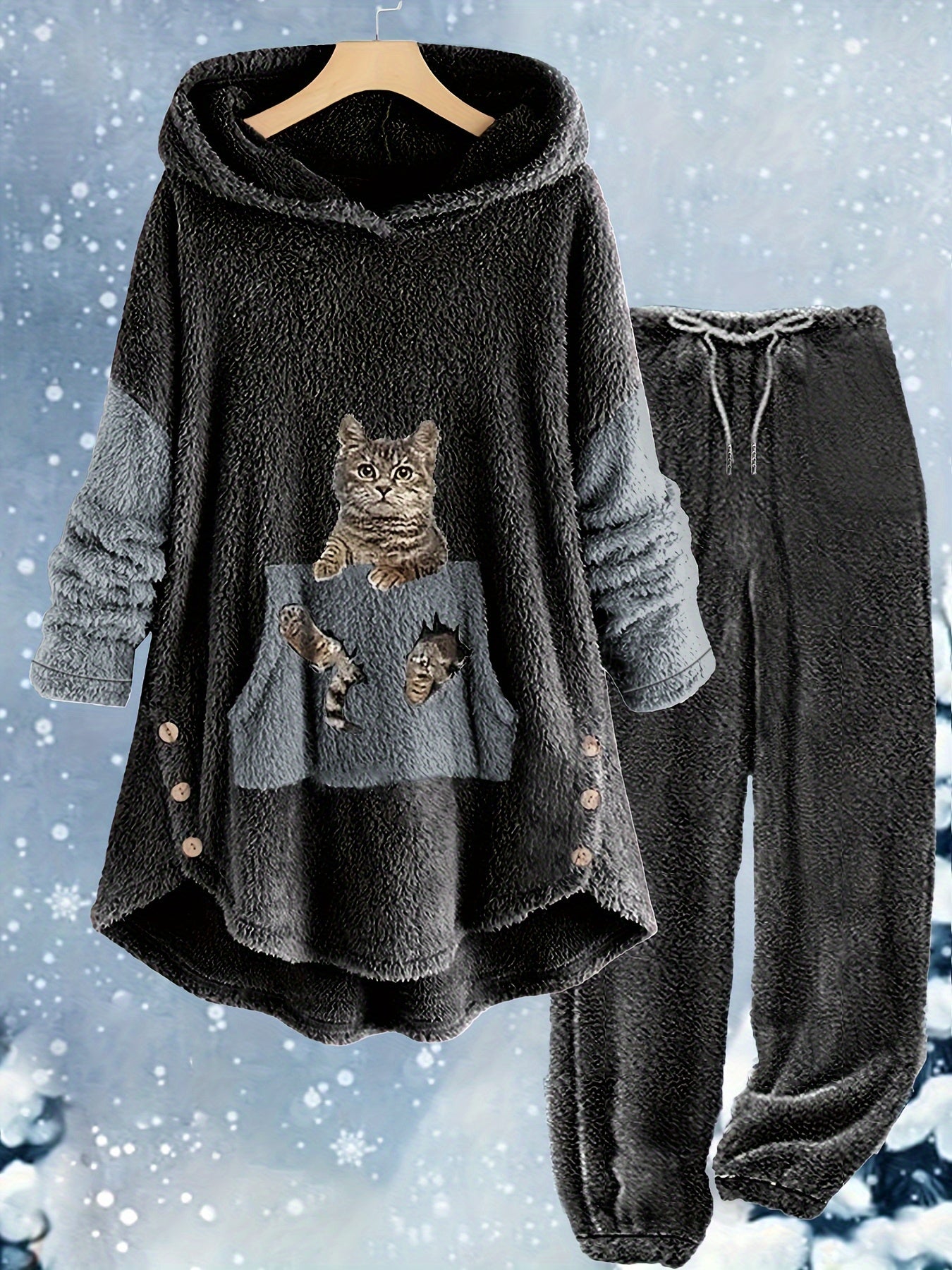 A two-piece cozy loungewear set with cartoon cat designs on the top's front pocket. The set includes a hooded top with buttons and matching pants, both in soft, plush polyester material. The background is snowy. This is the Plus Size Casual Outfits Two Piece Set, Women's Plus Cat Print Fleece Long Sleeve Button Decor Hoodie & Pants Outfits 2 Piece Set by Maramalive™.