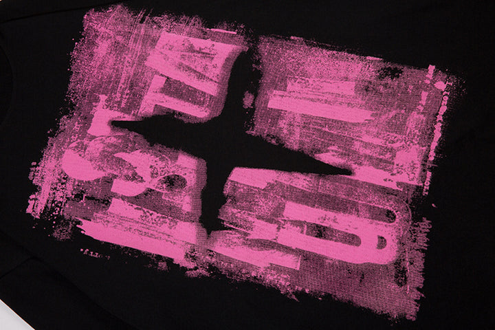 Close-up of a black cotton fabric with a distressed pink rectangular design and an abstract cross-like shape in the center of the Men's Dark Color Graffiti Printing Long-sleeved T-shirt by Maramalive™.