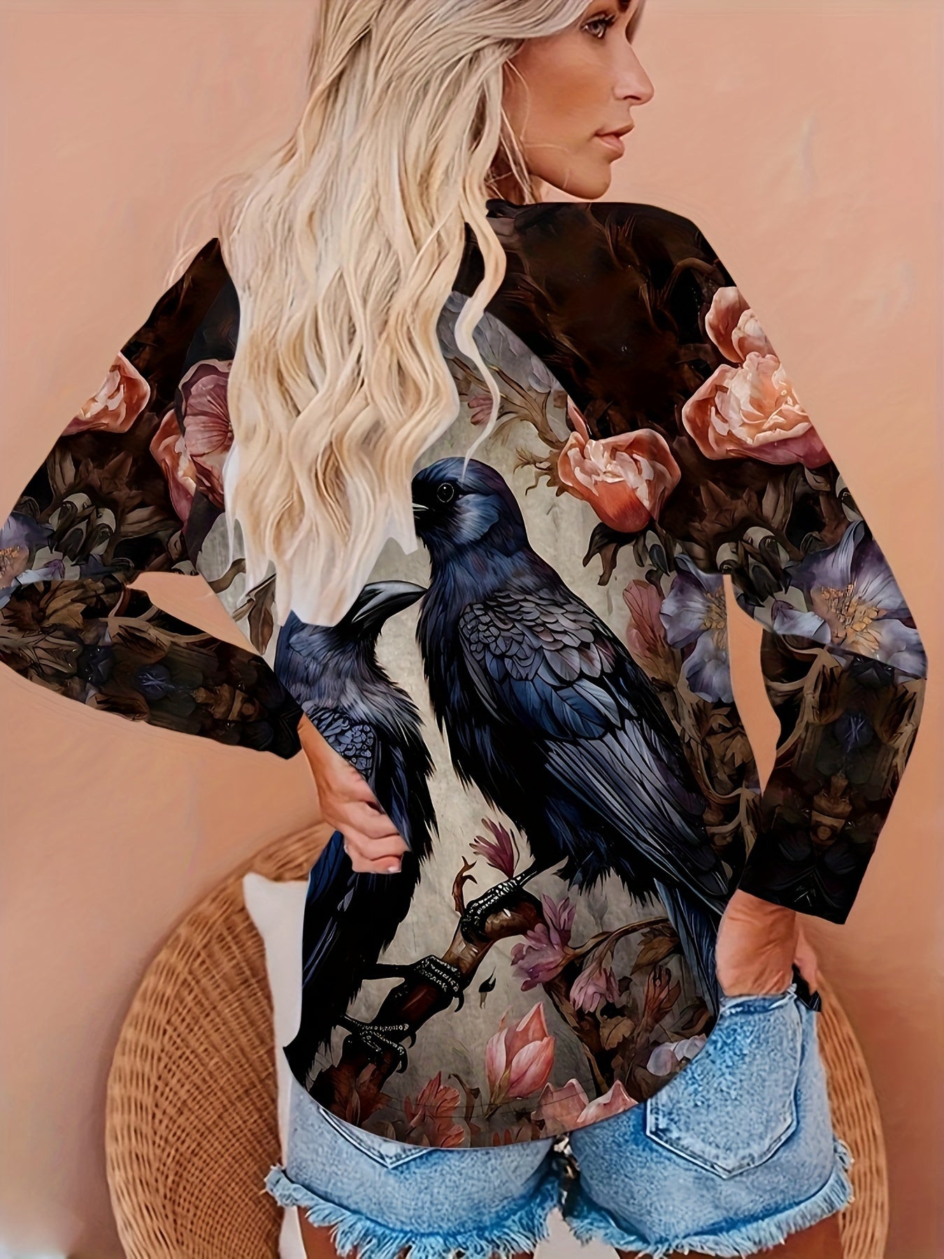 A person with long blonde hair wears a Birds & Floral Print T-shirt, Vintage Crew Neck Long Sleeve T-shirt with a raven design on the back, paired with denim shorts. The outfit showcases micro elasticity for added comfort, perfect for a casual day out. This stylish piece is from Maramalive™ Women's Clothing line.