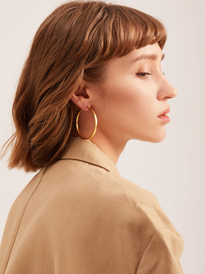 A pair of Maramalive™ Minimalist Circle Ear Buckle earrings on a white surface.