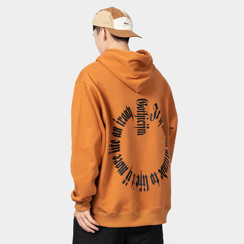Person wearing an orange Maramalive™ European Hip Hop Gothic Sweater Men's Hoodie with circular black text on the back, paired with a tan and white cap, facing away from the camera.