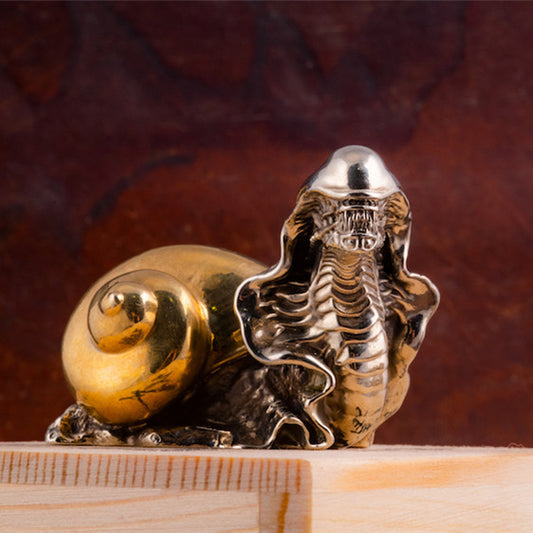 A Maramalive™ Bronze Two-color Study Steampunk Ornament snail sitting on top of a wooden box.