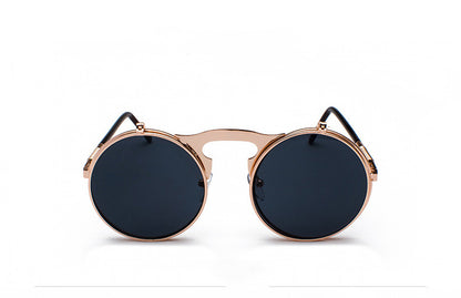 A pair of Maramalive™ Retro Metal Steampunk Flip Sunglasses Round Frame sitting on top of a pink surface.