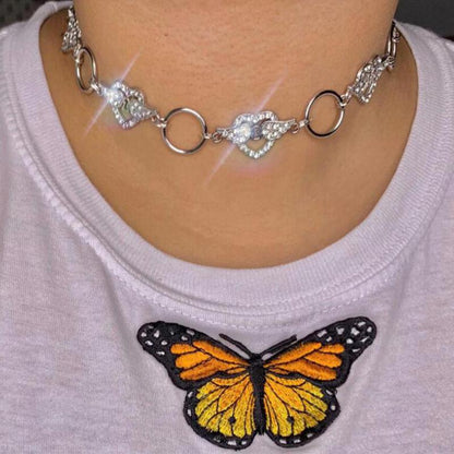A woman is wearing a Love Heart Flash Diamond Necklace with a butterfly on it. It is from the brand Maramalive™.