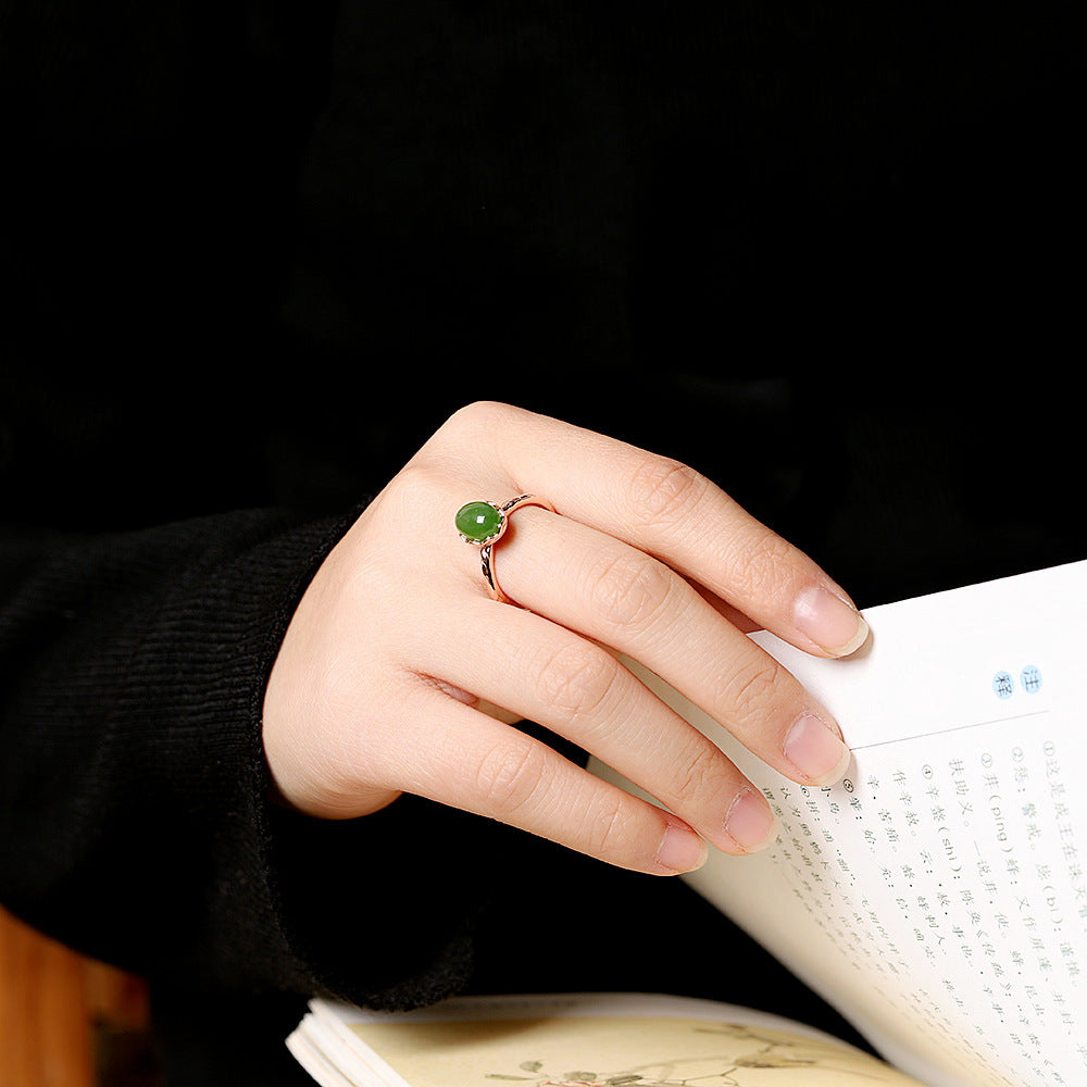 A woman's hand holding a book and a Maramalive™ Women's Ring.