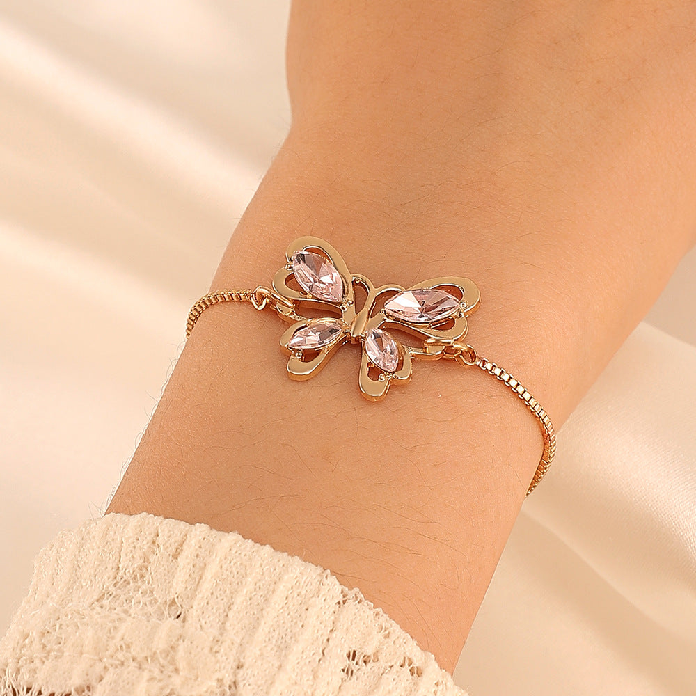 A woman wearing an "Elegance in Pink" - Affordable Luxury Crystal Butterfly Bracelet from Maramalive™.