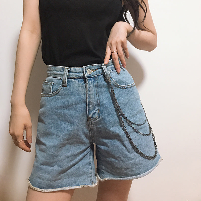 A woman in a black top and denim shorts posing in front of a wall wearing Maramalive™ Summer Chain Jewelry for Casual Jeans.