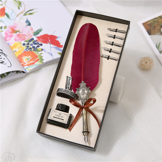 A box with a Vintage Quill Pen Gift Pen and a feather in it (brand: Maramalive™).