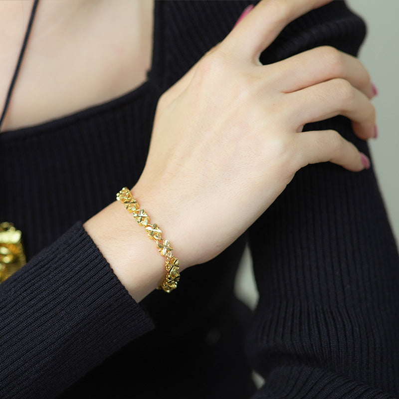 A woman's hand adorned with a Maramalive™ Lucky Charm Women's Bracelet - Four Leaf Clover Gold Charm Bracelet, showcasing the lucky charm of a four leaf clover.