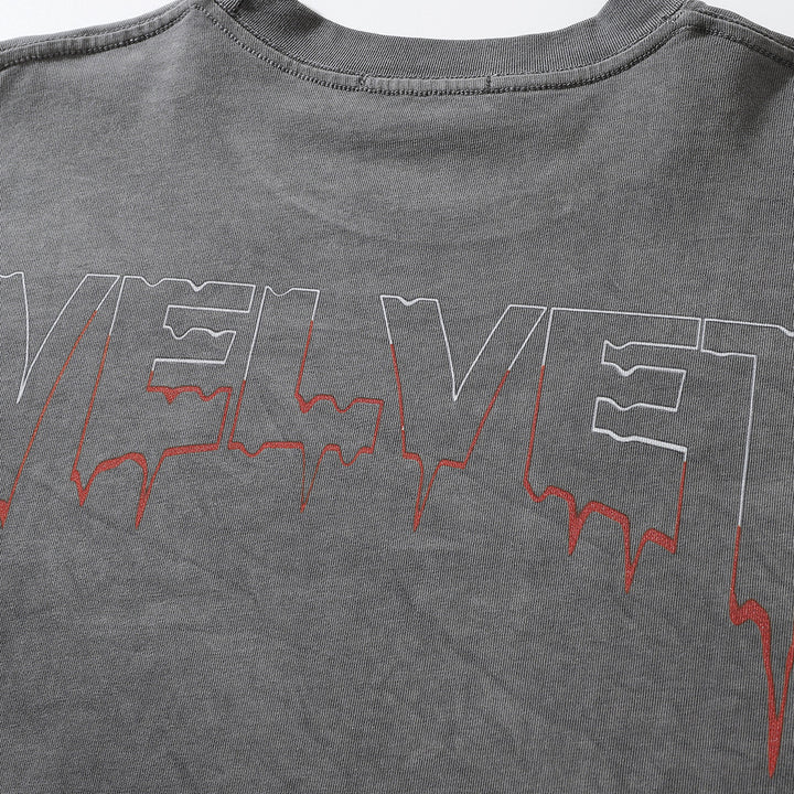 Close-up of a gray, collarless garment with the word "VELVET" printed on it in large, bold letters. The text has a dripping effect with red accents. The product is the Men's Dark Character Old Washed Long-sleeved T-shirt by Maramalive™.