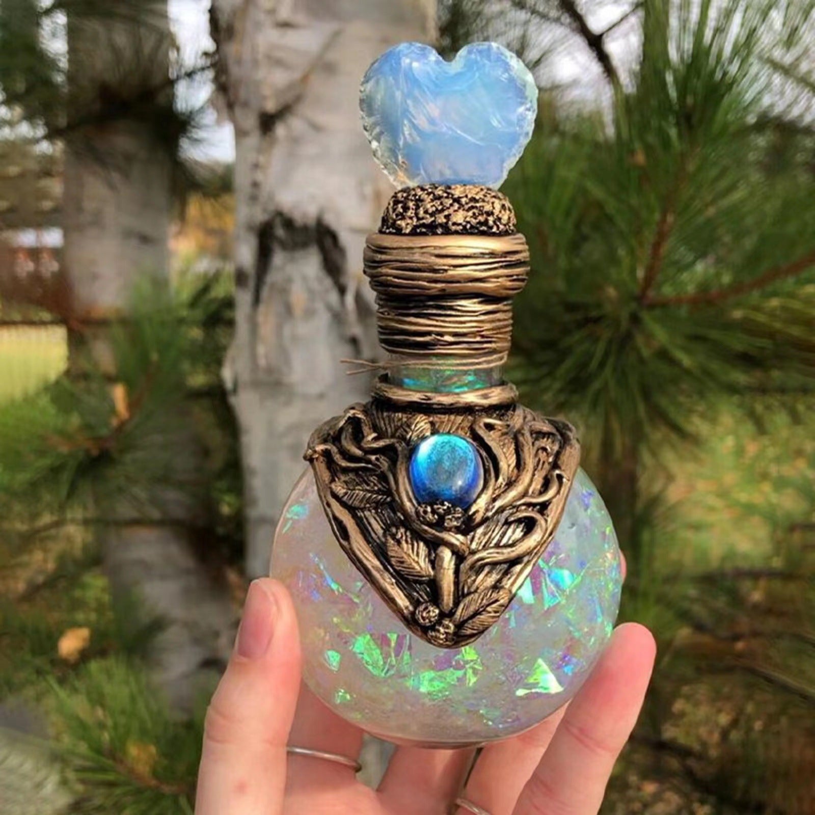 A person holding a Mermaid Moon Bottle perfume bottle by Maramalive™.