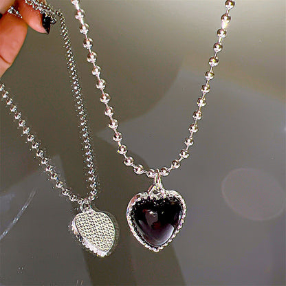 A hand holding a Maramalive™ Niche Creative Personality Affordable Luxury Advanced Love Micro Zircon-laid Necklace with a heart-shaped pendant.