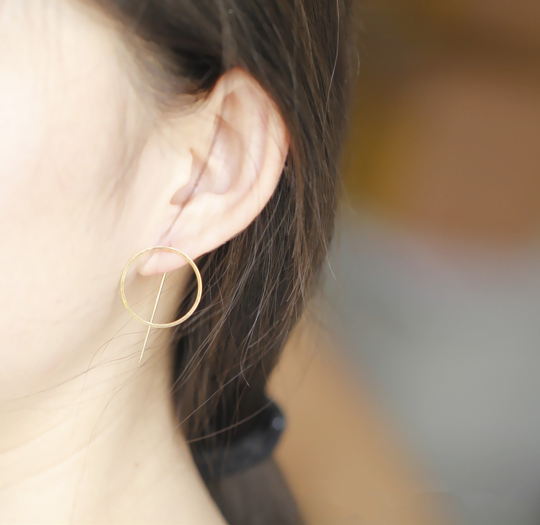 A woman wearing a pair of Maramalive™ Minimalist Copper Earrings.