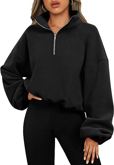 A person wearing a fashionable and simple Maramalive™ Loose Sport Pullover Hoodie Women Winter Solid Color Zipper Stand Collar Sweatshirt Thick Warm Clothing with a high collar over solid color black pants, standing with one hand on their hip.