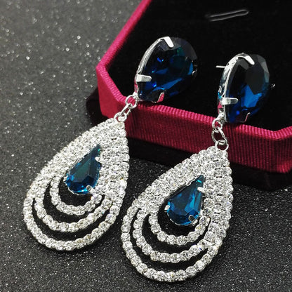 A pair of Maramalive™ Crystal Earrings with blue crystals and diamonds.