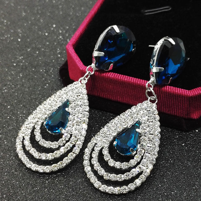 A pair of Maramalive™ Crystal Earrings with blue crystals and diamonds.