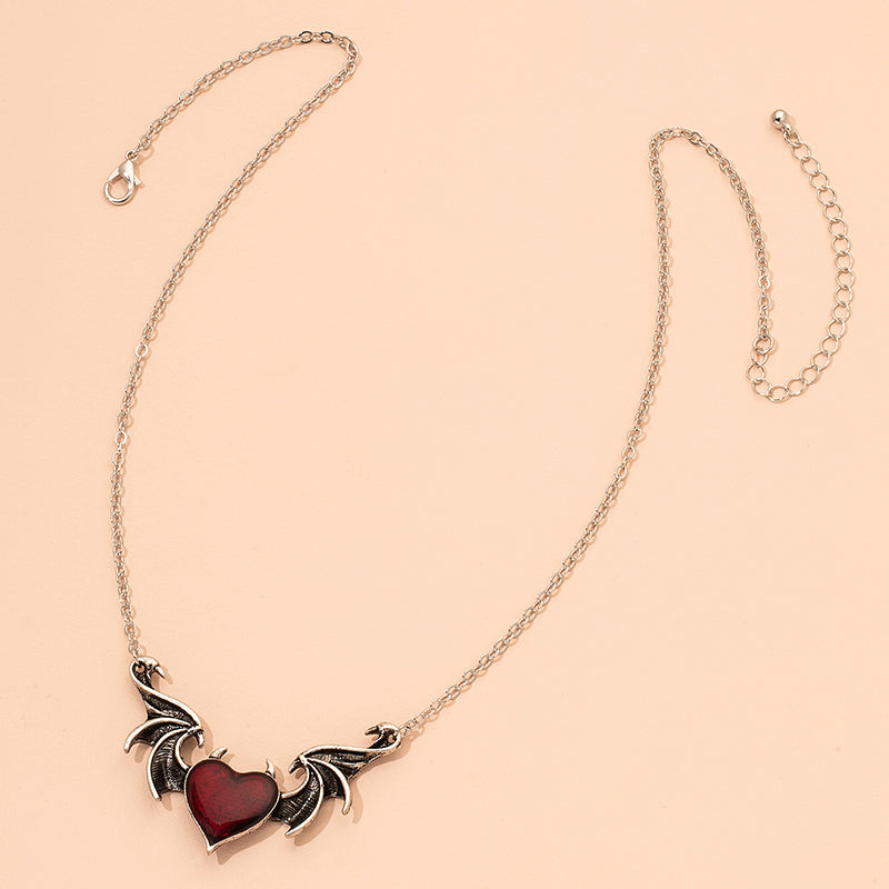 A Demon Wing Necklace Gothic Vintage from Maramalive™ with a red heart on it.