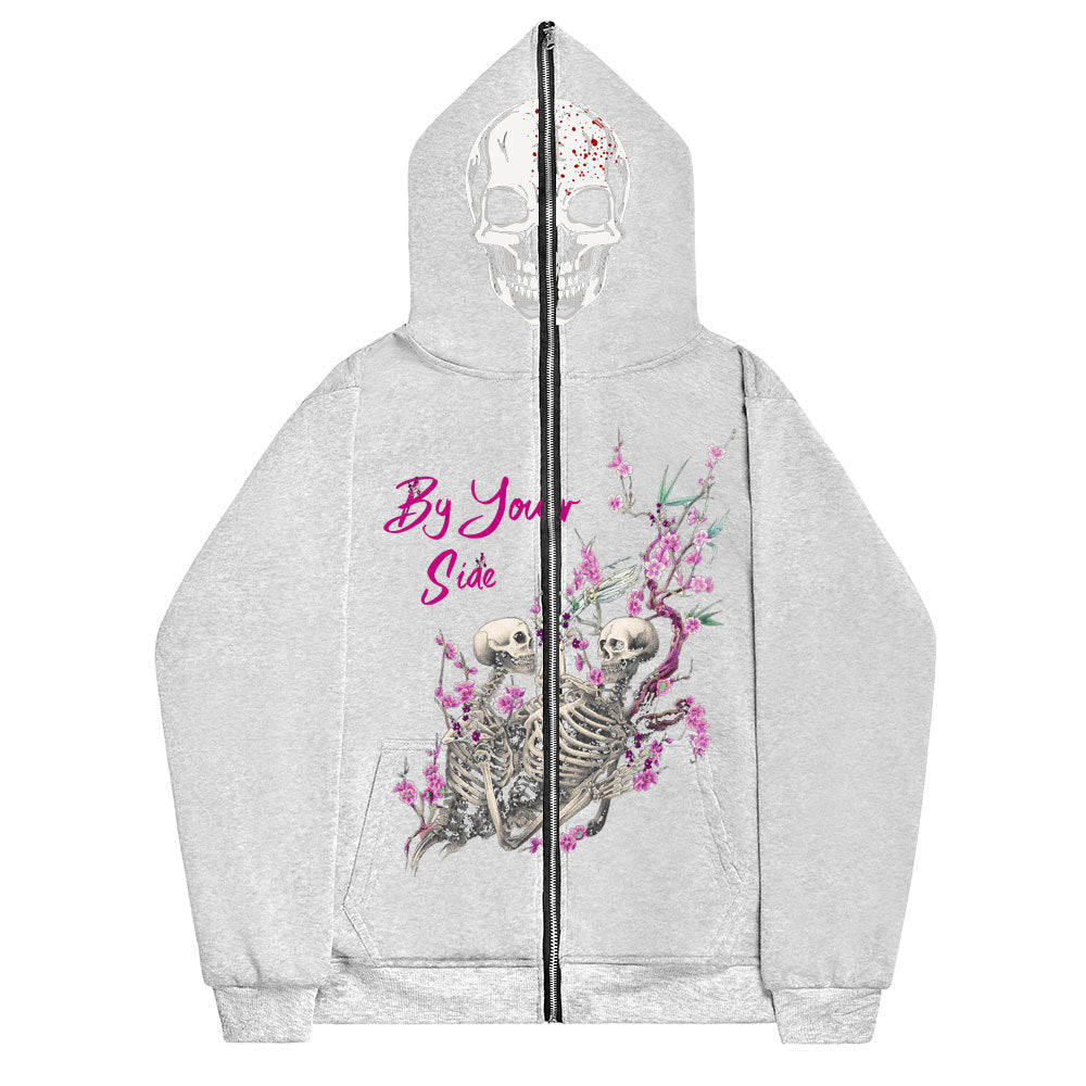Sporty gray zip-up hoodie crafted from soft cotton, featuring a front design of intertwined skeletons amidst pink cherry blossoms, with the text "By Your Side." The hood showcases a white skull with a partial floral pattern, giving it the cozy charm of a cardigan. This stylish item is the Gothic Couple Harajuku Black Sweatshirt Zipper Sweater by Maramalive™.