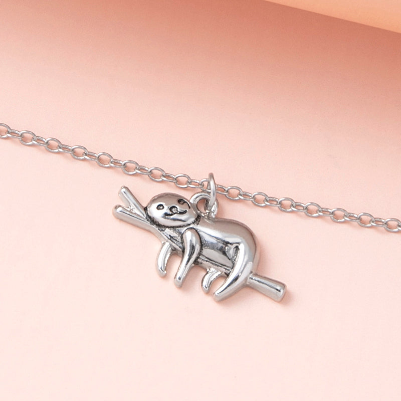 A Maramalive™ Silver Color Slow Down Be Happy Slider Sloth Pendant Necklace with a sloth on a branch.