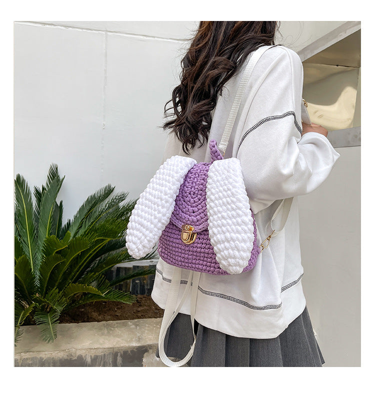 A woman holding a pink Homemade Hand Knitted Lock Cloth Crochet Big Ear Backpack by Maramalive™.