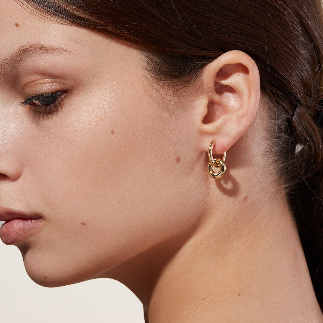 A woman wearing a pair of Maramalive™ Gold Double Hoop Earrings.