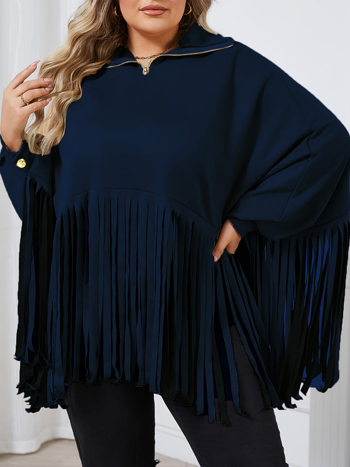 A person wearing a dark blue, long-sleeved, fringed top with batwing sleeves and a zipper detail at the collar, perfect for Fall/Winter: Maramalive™ Women's Plus Solid Batwing Sleeve Mock Neck Fringe Trim Cloak Top.