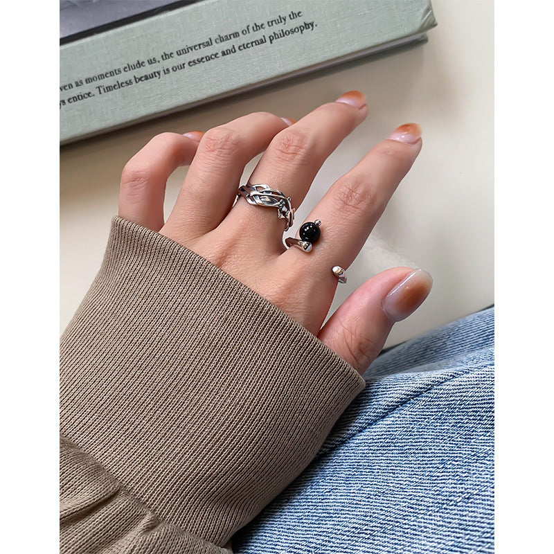 A woman's hand holding a Niche Light Luxury Geometric Irregular Black Onyx Ring by Maramalive™.