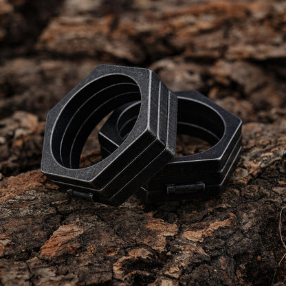 A black Maramalive™ Retro Titanium Steel Ring sitting on a piece of wood.
