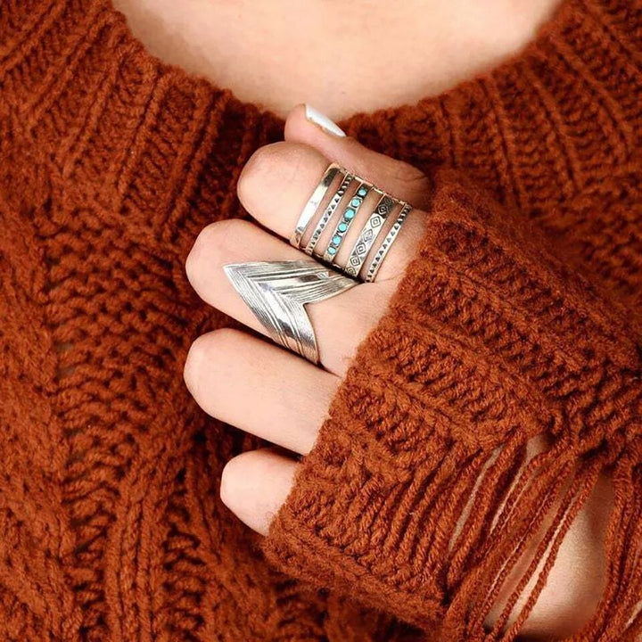 A woman wearing a sweater and a pair of Maramalive™ Fashion Hollowed-out Vintage Turquoise Rings.