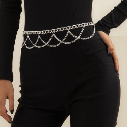 A woman wearing a black jumpsuit with a Maramalive™ Geometric Aluminum Body Chain belt.