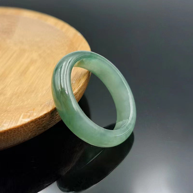 A Natural Jade Ring by Maramalive™ sitting on a wooden table.