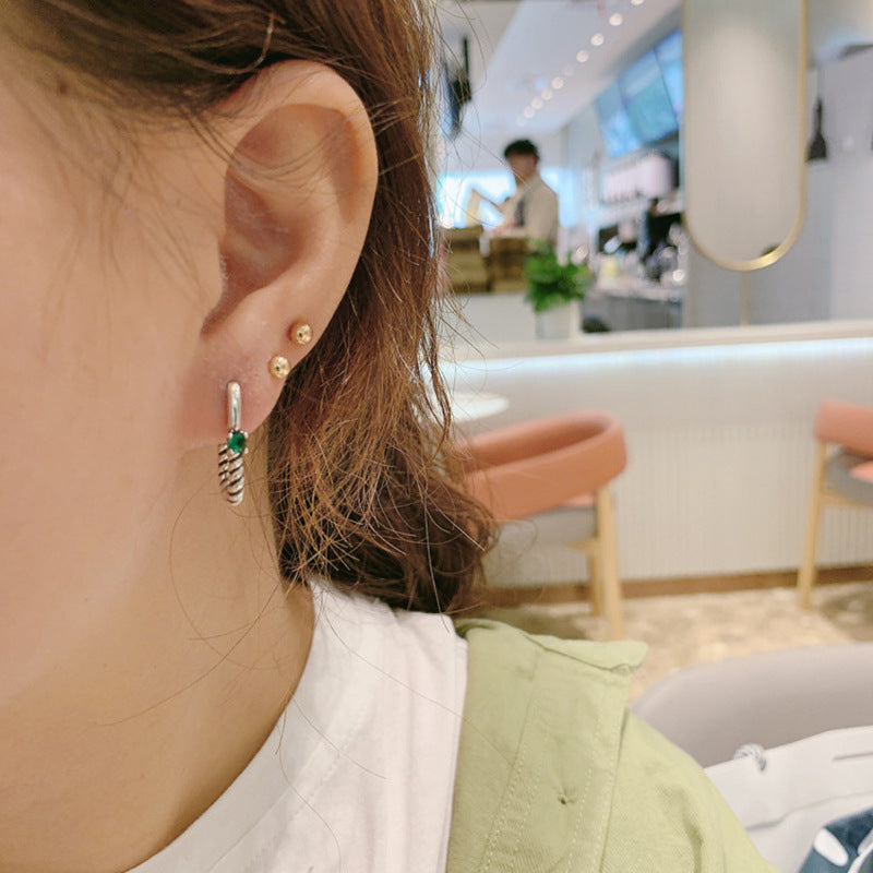 A woman wearing a white shirt and a pair of Maramalive™ Geometric Earrings.