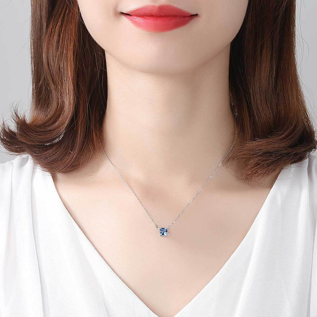 A woman wearing a Maramalive™ Stunning 925 Silver Pendant Blue Crystal Necklace and Pendant Jewelry Set.