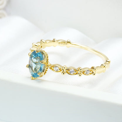 A woman's hand holding a Vintage London Blue Topaz Horse Eye Ring from Maramalive™.
