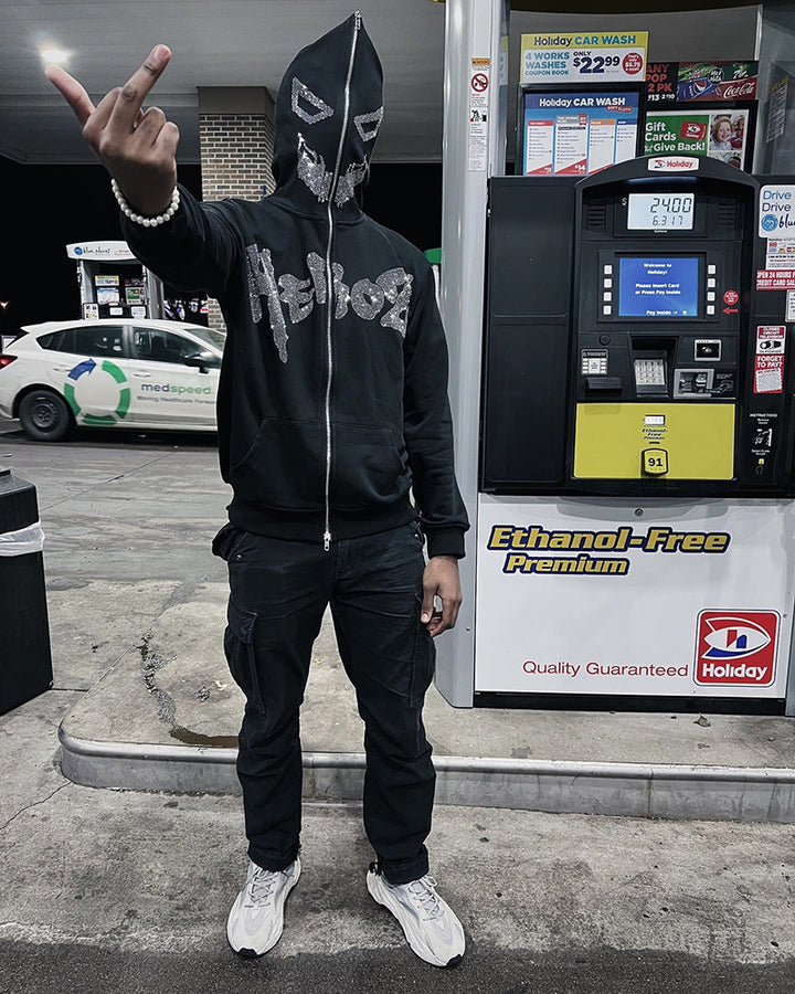 A man with a super attitude in a unisex gothic dark Diamante-Studded Hoodie Sweatshirt for Edgy Style by Maramalive™ standing next to a gas pump.