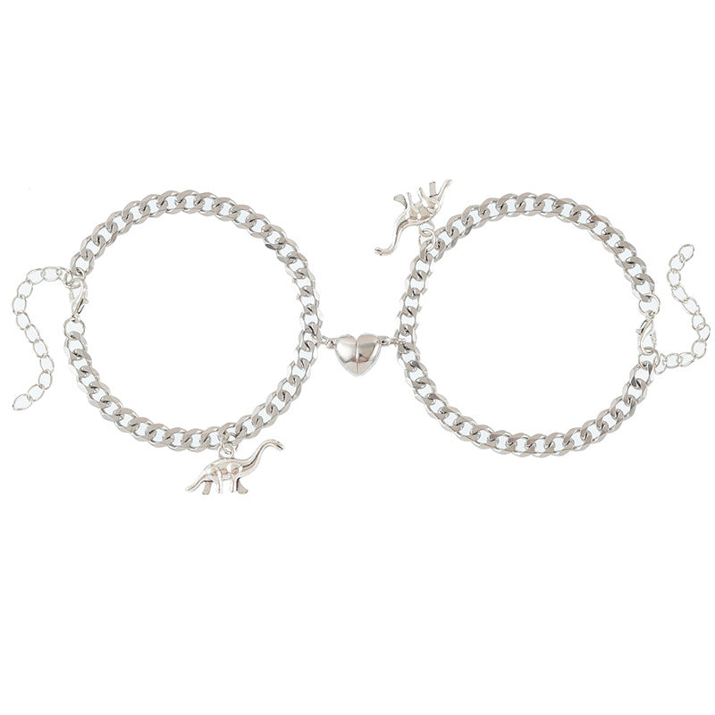 A woman's hands are holding two Maramalive™ Creative Dinosaur Stainless Steel Chain Couple Love Heart-shaped Bracelets.