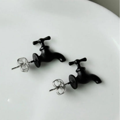 Silver and black punk faucet earring on ear