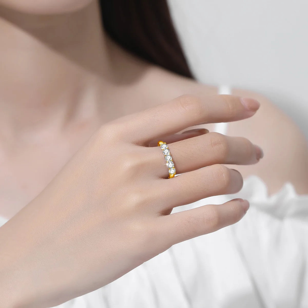 A hand wearing the Maramalive™ With Certificate Original Solid 18K Gold Moissanite Ring For Women 5 Stone Luxury Wedding Jewelry With Stamp Gift Female against a white background.