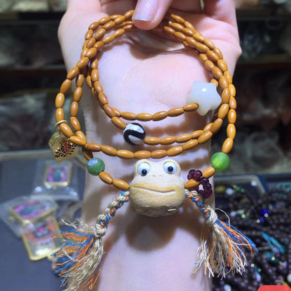 A person is holding an Olive Nut Multi-Circle Bohemian Bracelet with a frog on it from Maramalive™.