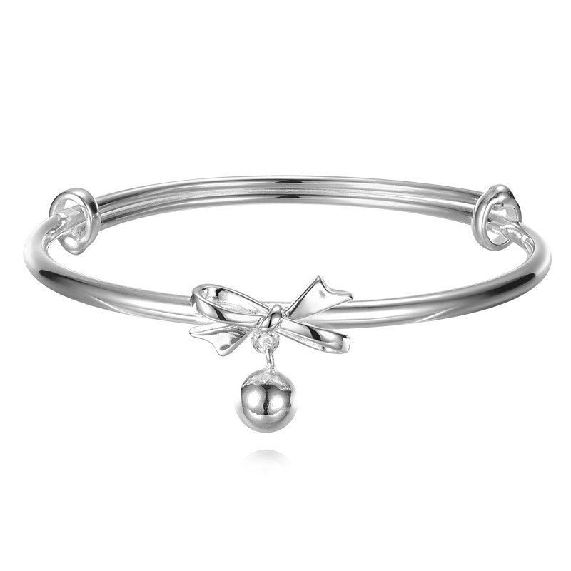 A woman in a white dress is posing with her hand on her face, wearing the Minimalistic Jewelry Simple Mobius Silver Bracelet Stunning Gift for Her I Love It by Maramalive™.