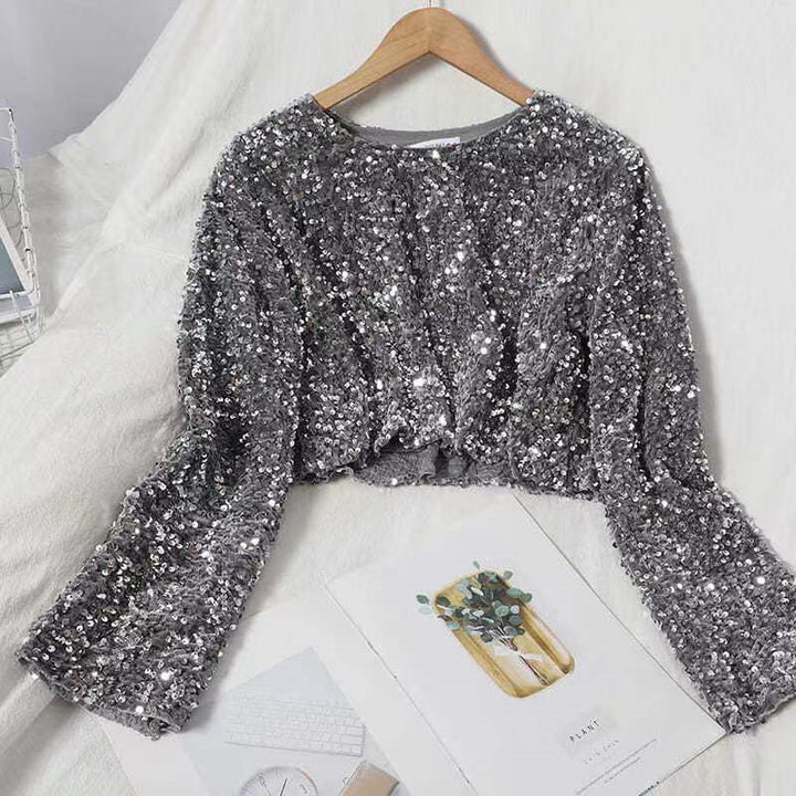 A fashionista's bed adorned with two Shimmery Sequined Crop Tops for dazzling style, including a luxurious Maramalive™ Cashmere Sequined Crop Top.