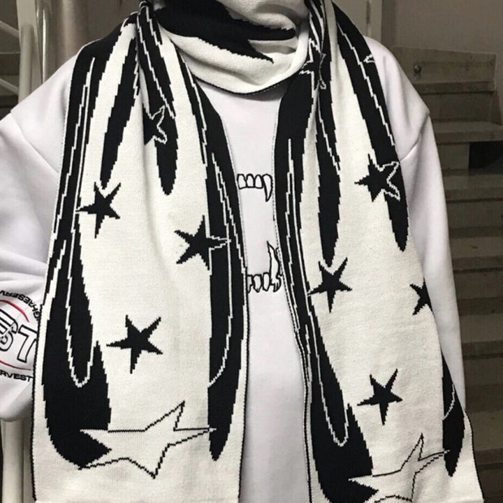 A person wearing a black and white, star-patterned Maramalive™ European And American Scarf Autumn And Winter New Dark Style Fire Element draped over a white sweatshirt.