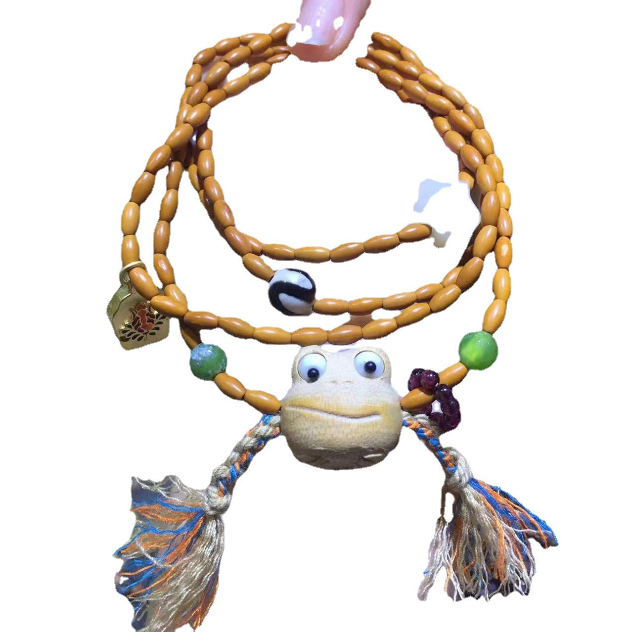 A person is holding an Olive Nut Multi-Circle Bohemian Bracelet with a frog on it from Maramalive™.