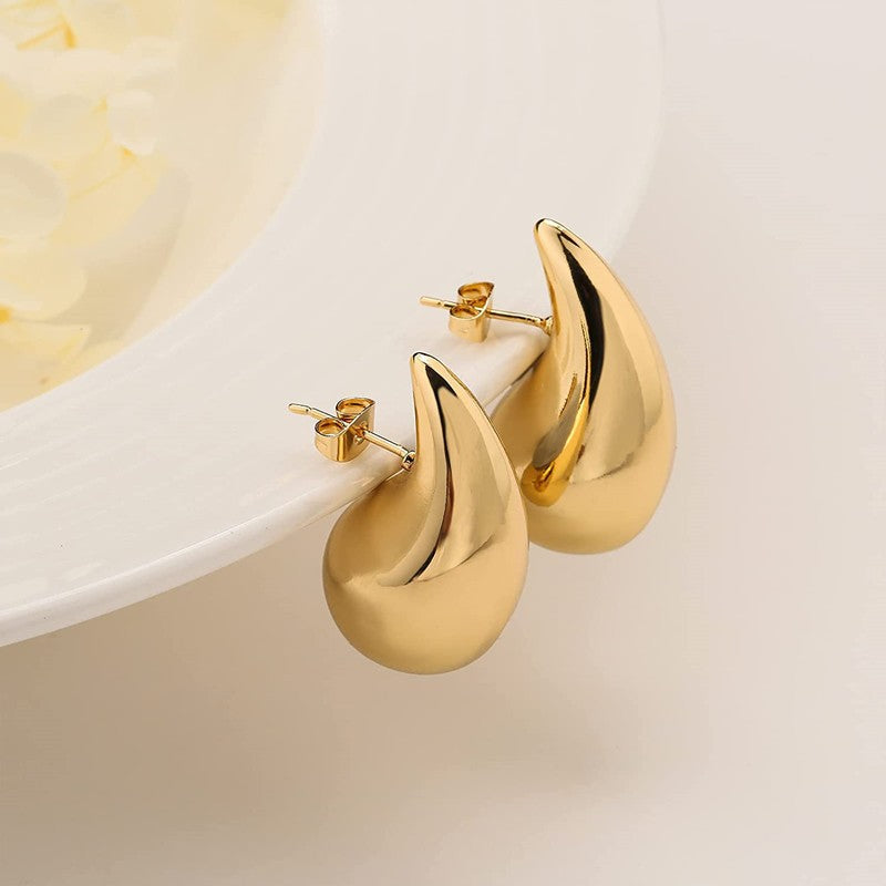 A pair of Minimalistic Water Drops Earrings Temperament Wild 14K Gold Plated Glossy by Maramalive™ on a white plate.